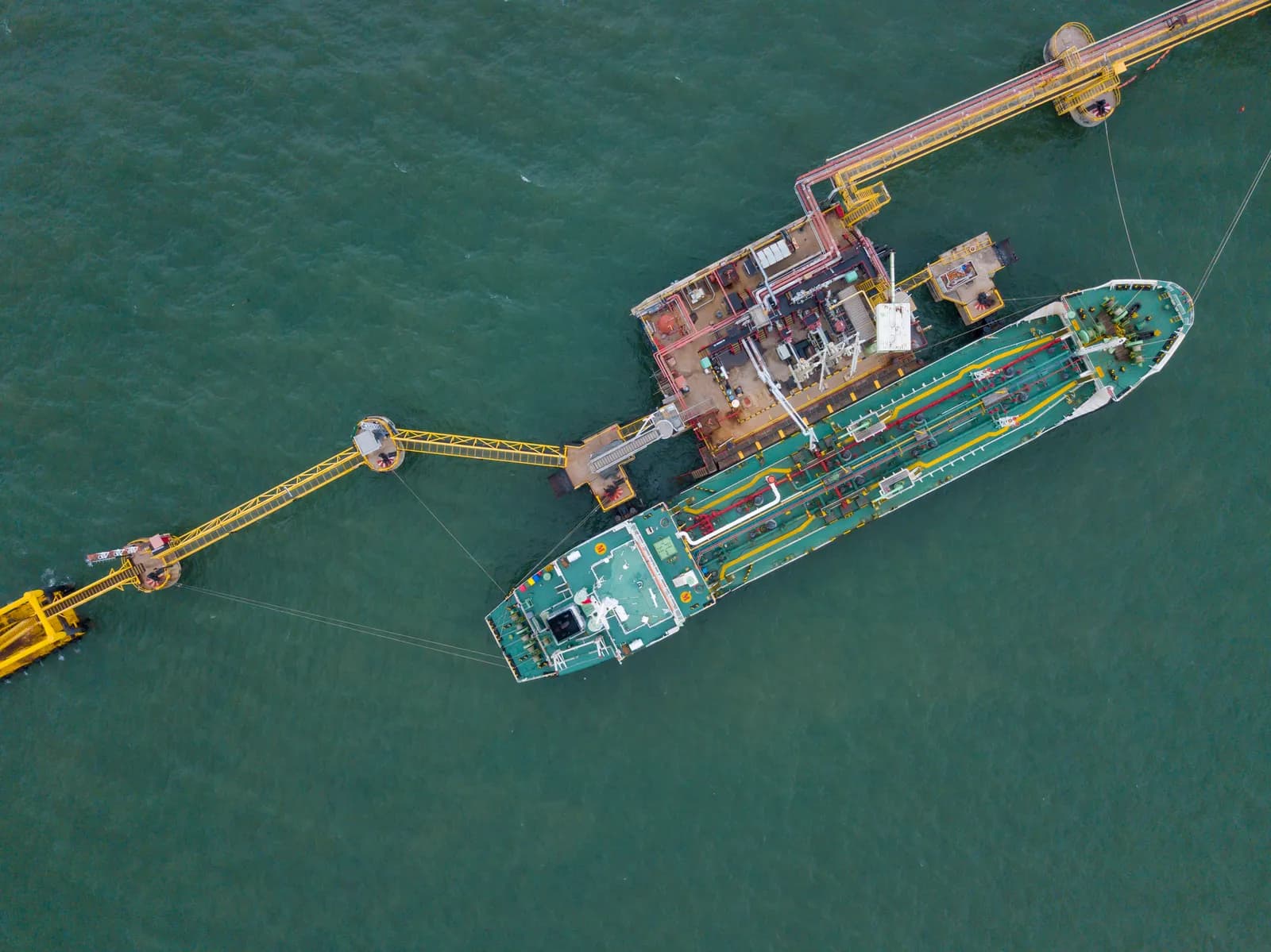 Aerial view of a tanker vessel berthed alongside a marine terminal.